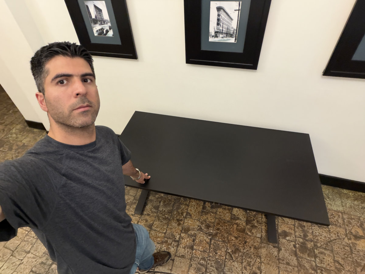 Eco Van Move staff inspecting and picking up an office desk purchased through Facebook Marketplace for a client.