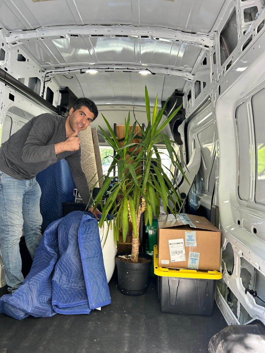 Eco Van Move loading household items and a large indoor plant into a cargo van for a small move in Vancouver.