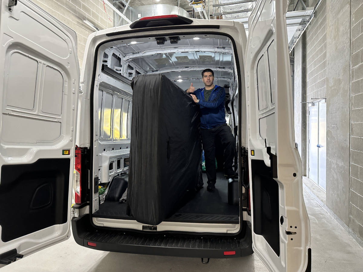 Eco Van Move staff transporting a protected mattress inside a cargo van for delivery in Metro Vancouver.