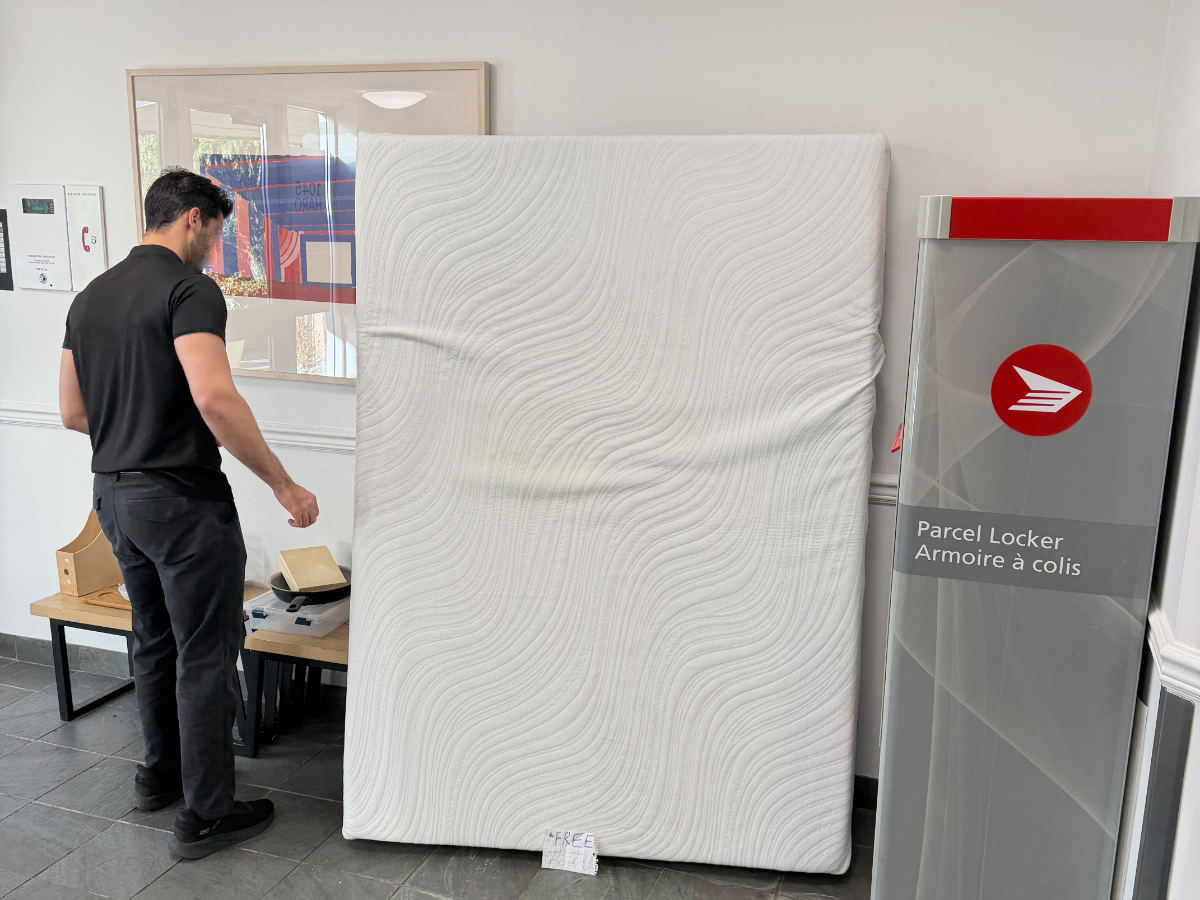 Eco Van Move removing and hauling away a used mattress from a residential building in Vancouver.